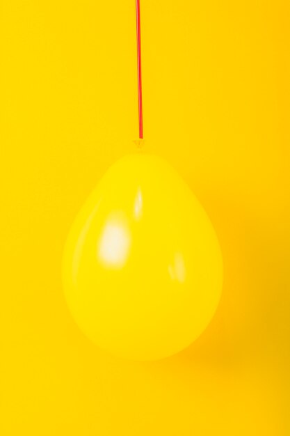 Shiny balloon over the yellow background