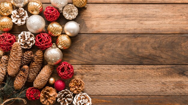 Shiny baubles with cones on table 