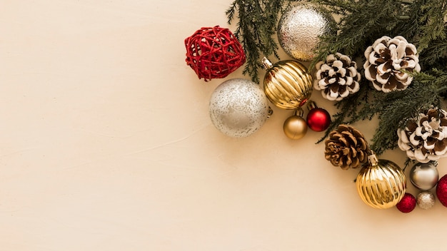 Shiny baubles with green branches on table 