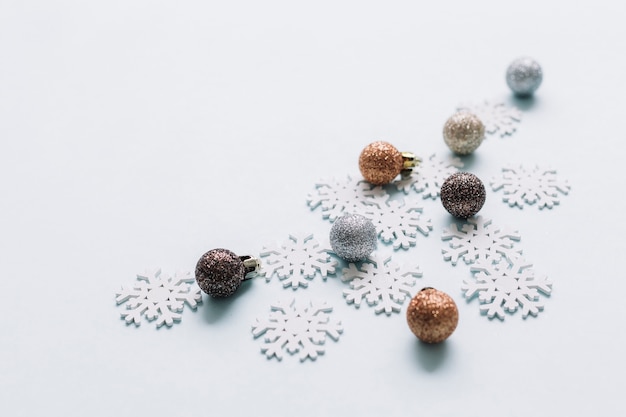 Shiny baubles with small snowflakes on table 