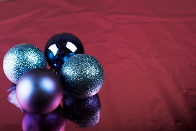 Блестящие рождественские шары, лежащие на бордовой ткани