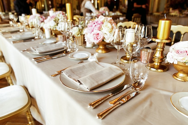 Shiny glassware and cutlery stand on the dinner table decorated 