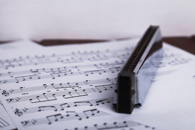 Shiny harmonica on sheet music