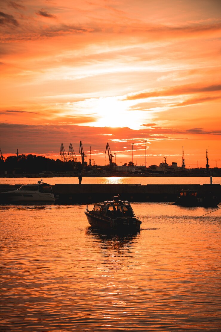 無料Photo 水面に映る美しい夕日の海に船