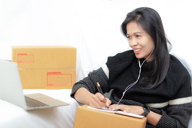 Shipping online asian woman start up small business owner the check list accepts the order online