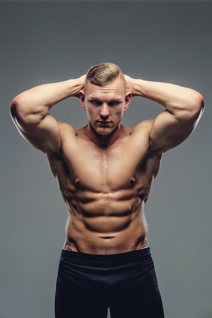 Shirtless abdominal man on a grey background.