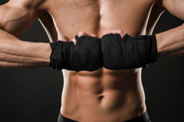 Shirtless athletic man posing with boxing gloves