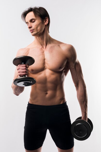Shirtless athletic man working out with weights