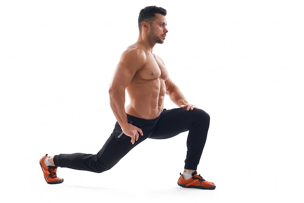 Shirtless bodybuilder stretching, isolated on white.