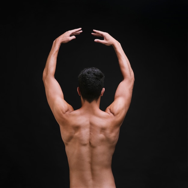 Free photo shirtless dancer raising arms during performance