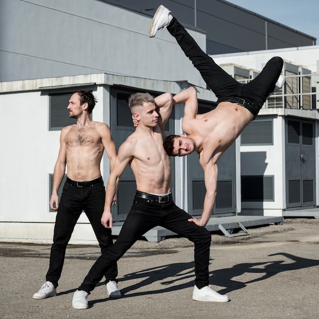 Free photo shirtless hip hop performers posing outside