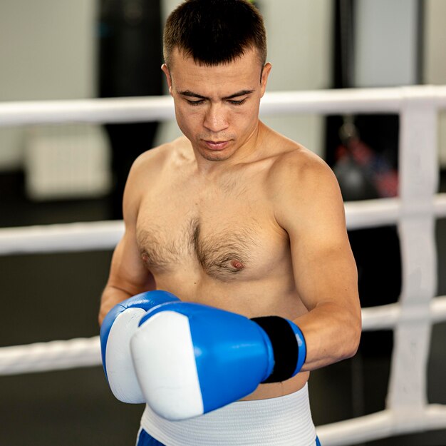 Shirtless male boxer with protective gloves