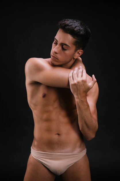 Shirtless male stretching neck and arm