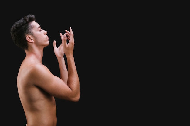 Человек без рубашки, жестикулирующий во время танца