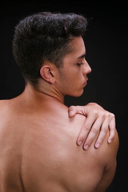 Shirtless man stretching shoulder muscles