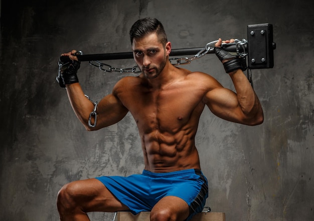 Free photo shirtless muscular man holding a big hammer on his shoulders.