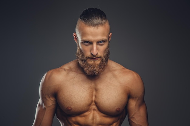 Shirtless sporty bearded male isolated on a grey background.