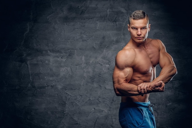 Free photo shirtless sporty male isolated with contrast illumination on grey vignette background.