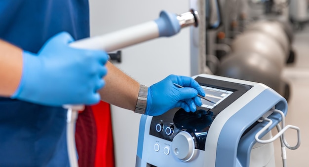 Free Photo shock wave therapy device with male doctor hands in rubber gloves