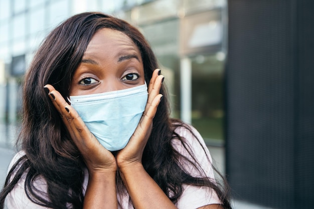 Shocked african american woman standing outside wear mask Premium Photo