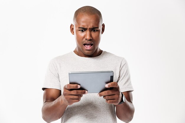 태블릿 컴퓨터를 사용 하여 충격 된 아프리카 남자