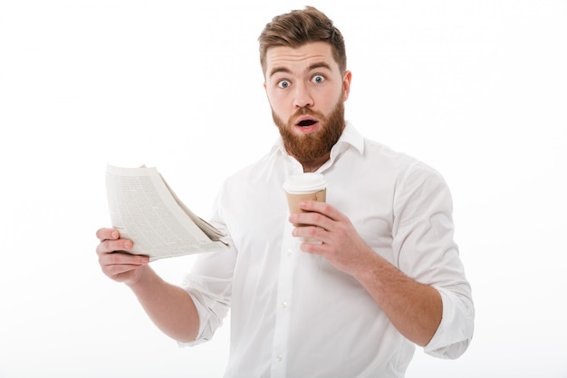 Бесплатное фото Шокированный бородатый мужчина в деловой одежде держит газету