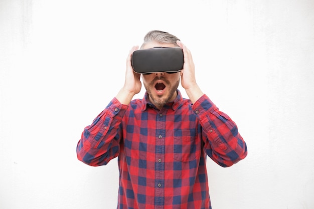 Shocked bearded man in VR headset