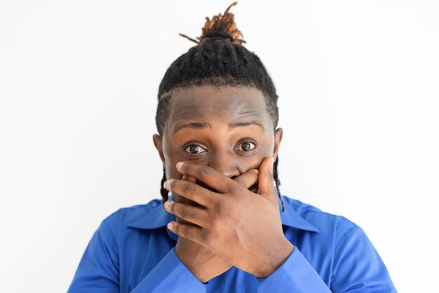 Free photo shocked black man covering mouth with both hands