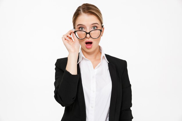 Shocked blonde business woman with open mouth over white