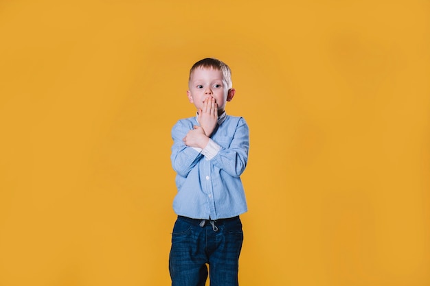 Free photo shocked boy covering mouth