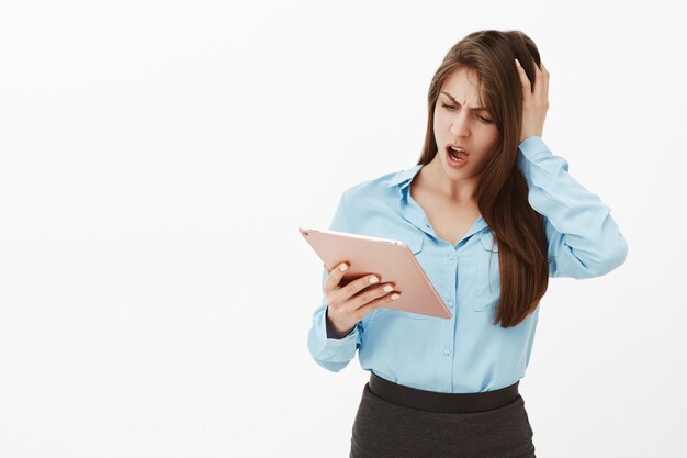 Shocked brunette businesswoman posing in the studio