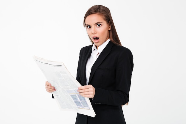 Shocked business woman holding newspaper.