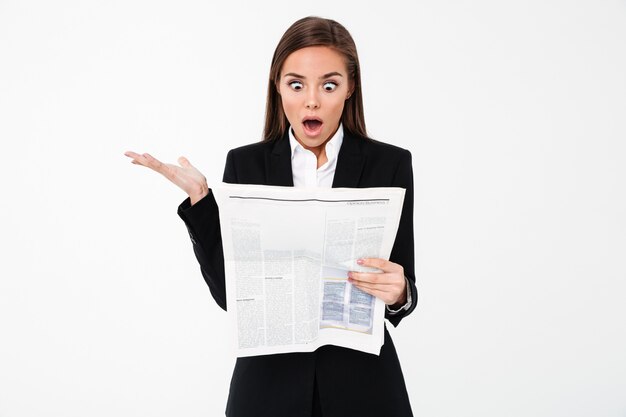 Shocked business woman holding newspaper.