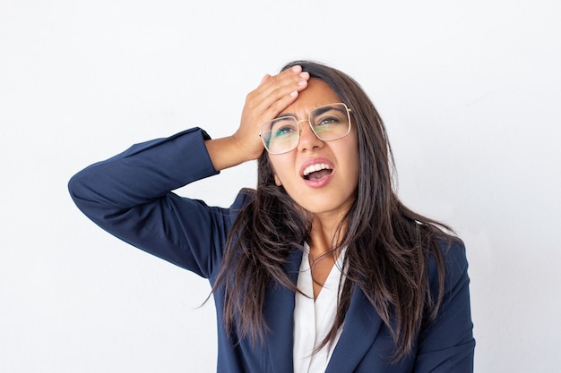 Shocked businesswoman with hand on forehead