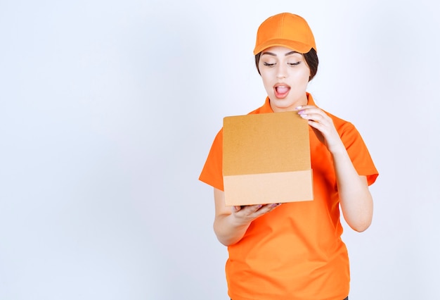 Shocked delivery woman opening her package