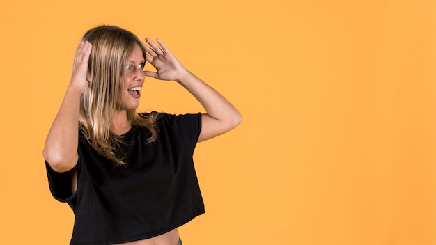 Shocked disable woman standing against bright yellow backdrop