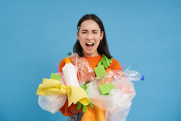 無料写真 ショックを受けた環境活動家がボトルや整理されていない衣服を見て動揺しながら、リサイクルするために大量のプラスチックを回収