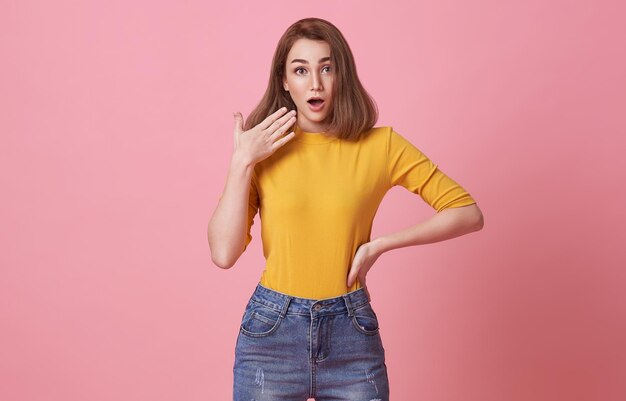 Shocked excited Beautiful woman with mouth open isolated on pink studio background