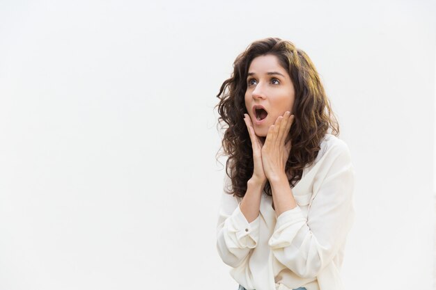 Shocked excited woman gasping, touching cheeks