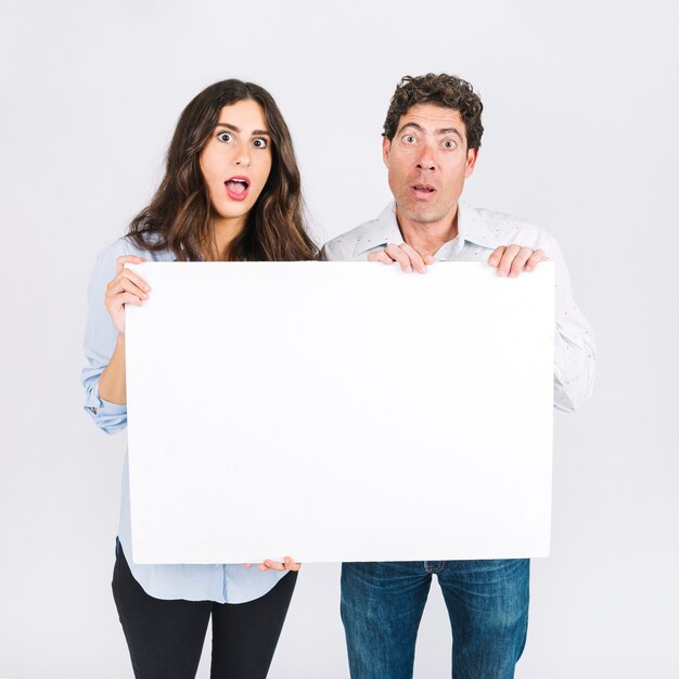 Shocked father and daughter holding empty banner