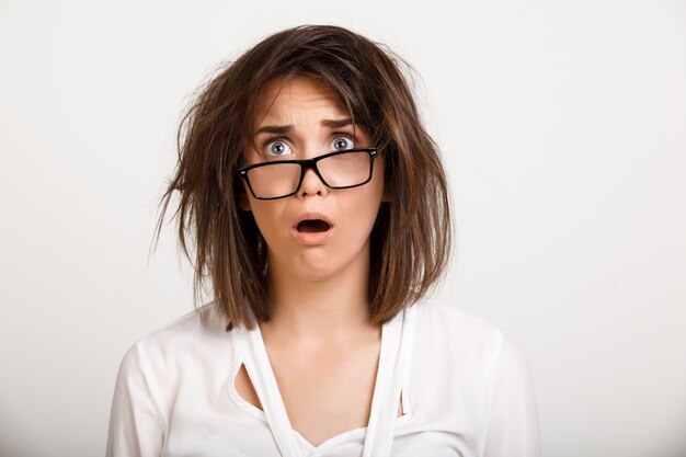 Shocked gasping woman in glasses with messy hair