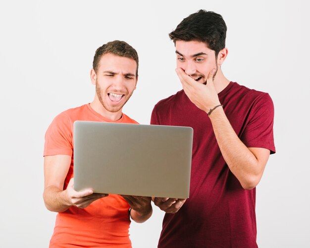 Shocked gay couple looking at laptop