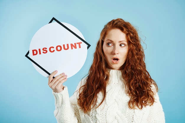 Free photo shocked girl showing blank sale banner