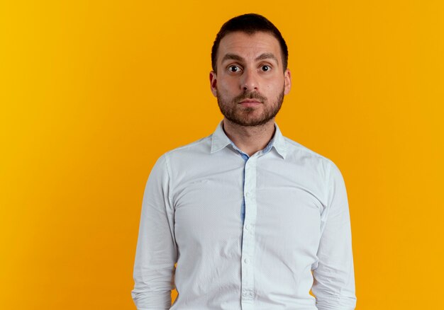 Shocked handsome man looking isolated on orange wall