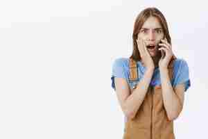 Free photo shocked and horrified woman receive bad news while talking on mobile phone