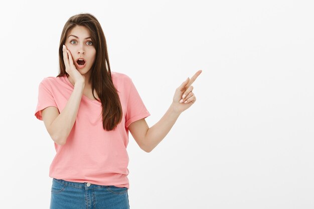 Shocked and impressed brunette woman posing in the studio