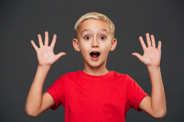 Shocked little boy child standing isolated