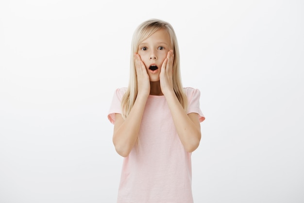 Shocked little girl drop jaw and stare impressed