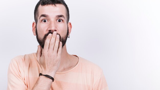 Shocked man covering mouth