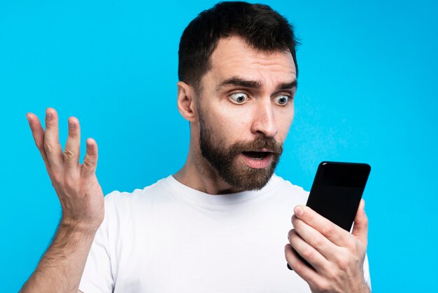 Shocked man looking at smartphone